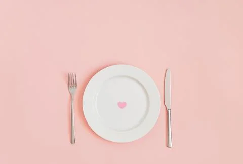 Festive romantic minimal table setting with a heart in a plate Stock Photos