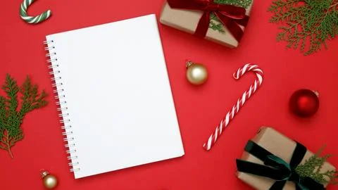 Festive setup, mockup of white notebook surrounded by wrapped Christmas gifts Stock Photos