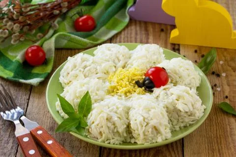 Festive snack on Easter table. Salad with eggs, ham, pickled cucumbers. Stock Photos