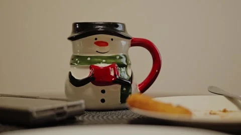Festive Snowman Mug on Dining Table Creating Cozy Holiday Atmosphere Stock Footage 338430899