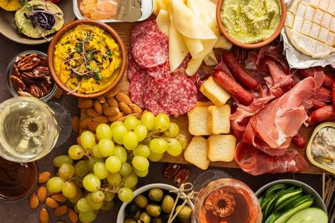 This festive spread features an array of cheese, cured meats, hummus, nuts, a Foto stock