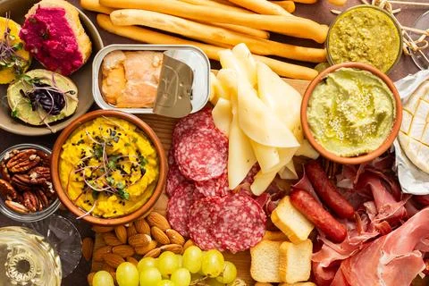 This festive spread features an array of cheese, cured meats, hummus, nuts,.. Foto stock