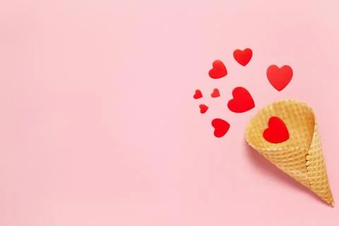 Festive spring flat lay. Red hearts in waffle cone on pastel pink background, Stock Photos