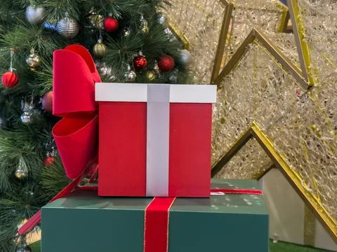 Festive Stack of Christmas Presents Adorned with a Large Red Bow Beside a D.. Stock Photos