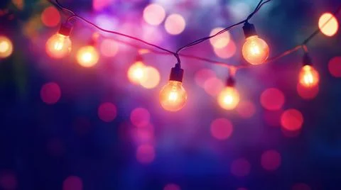 Festive string lights glowing against a colorful bokeh background in a Foto stock