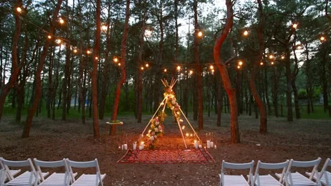 Festive string lights illumination on boho tipi arch decor on outdoor wedding Stock Footage 157212499