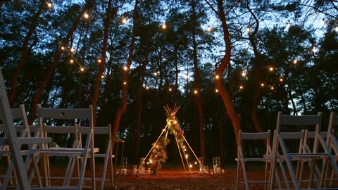 Festive string lights illumination on boho tipi arch decor on outdoor wedding Stock Footage 157212558