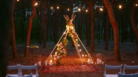 Festive string lights illumination on boho tipi arch decor on outdoor wedding Stock Footage 157327991
