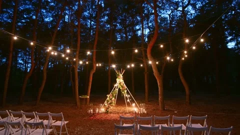 Festive string lights illumination on boho tipi arch decor on outdoor wedding Stock Footage 157652331