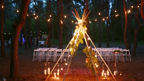 Festive string lights illumination on boho tipi arch decor on outdoor wedding Stock Footage 158197054
