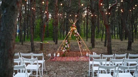 Festive string lights illumination on boho tipi arch decor on outdoor wedding Stock Footage 166954544