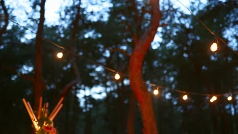 Festive string lights illumination on boho tipi arch decor on outdoor wedding Stock Footage 166954879