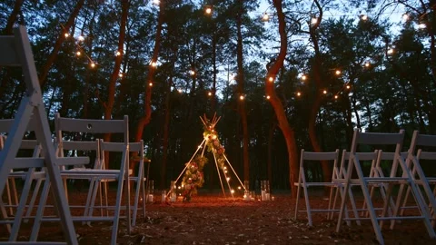Festive string lights illumination on boho tipi arch decor on outdoor wedding Stock Footage 168120701