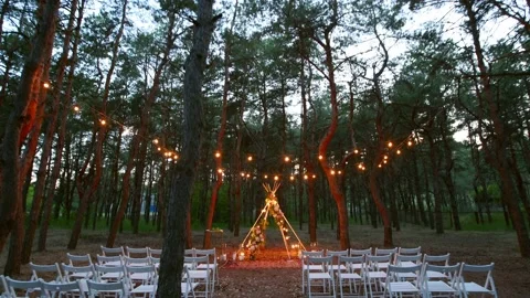 Festive string lights illumination on boho tipi arch decor on outdoor wedding Stock Footage 178373686