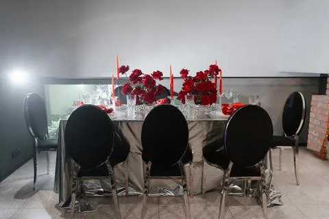 Festive table for 6-8 persons decorated with red roses, candles, napkins Stock Photos
