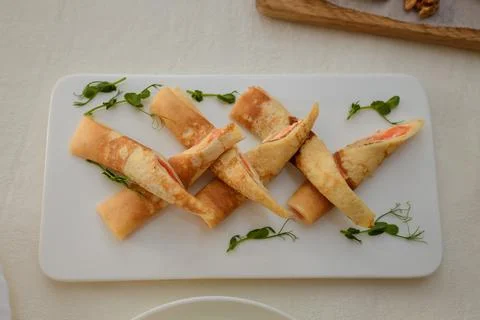 Festive table with appetizers. Pancakes with red fish salmon and microgreen Stock Photos