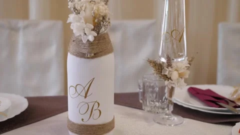 On the festive table is a bottle of wine with the initials of the newlyweds.  Video stock 281627973