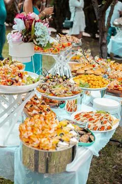 Festive table with buffet appetizers decorated with flowers Stock Photos