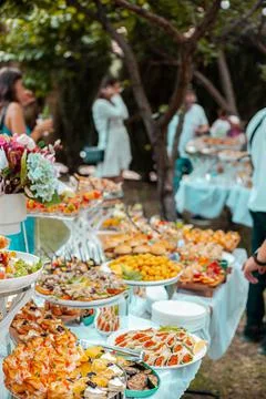 Festive table with buffet appetizers decorated with flowers Stock Photos