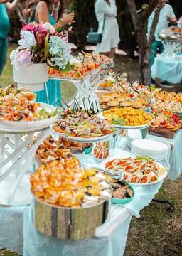 Festive table with buffet appetizers decorated with flowers Stock Photos