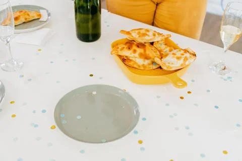 Festive table with cider, empanadas and confetti celebration Stock Photos