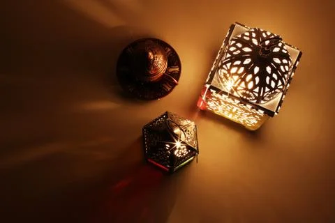 Festive table composition of glowing Moroccan ornamental lanterns and bronze tea 写真素材