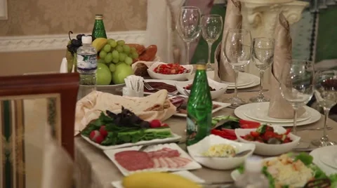 Festive table covered with. Plates and bottles food drinks. And a variety of dis Stock Footage 49446720