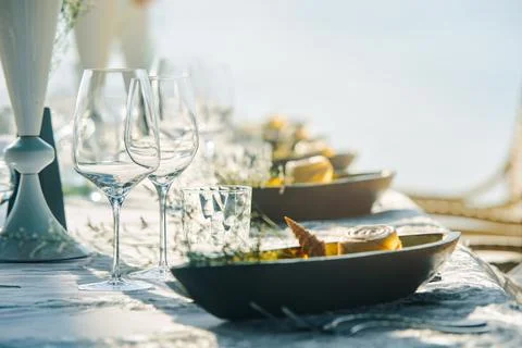 Festive table decor wine glasses and table setting in on beach.. Focus on dis Фото