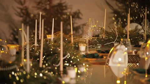 A festive table decorated with Christmas tree branches, garlands, and candles. Stock Footage 324850664