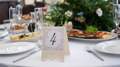 Festive table decorated with flowers with snacks, glasses and a white tablecloth Stock Footage 129525144