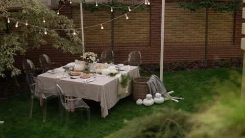 The festive table is decorated with pumpkins, flowers and herbs. Halloween party Видео 141966022