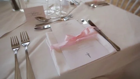Festive table decoration arranged close up - menu napkin tied with pink ribbon Stock Footage 70684459