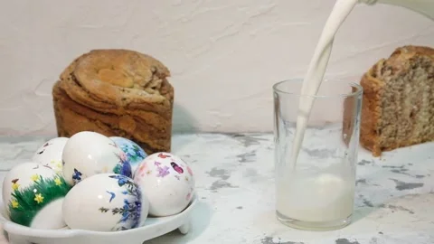 Festive table for Easter, Kulich, boiled eggs with a pattern and a glass of milk Stock Footage 185482347