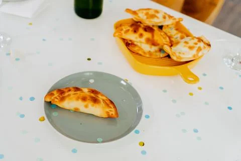 Festive table with empanadas, drinks and confetti Foto stock