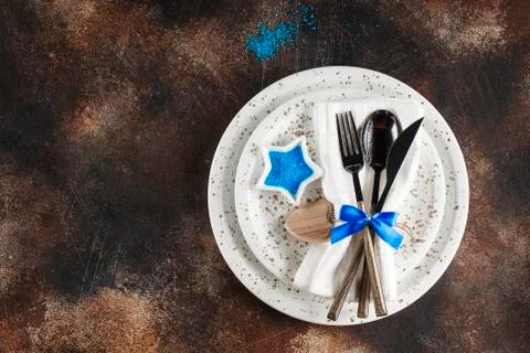 Festive table place setting. Crockery and cutlery on a dark textured backgrou Stock Photos