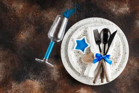 Festive table place setting. Crockery and cutlery on a dark textured backgrou Stock Photos