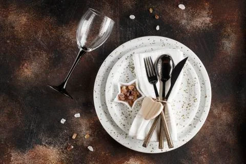 Festive table place setting. Crockery and cutlery on a dark textured backgrou Stock Photos