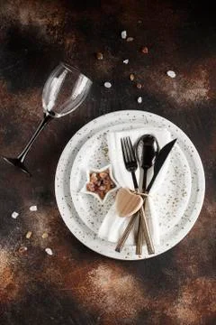 Festive table place setting. Crockery and cutlery on a dark textured backgrou Stock Photos