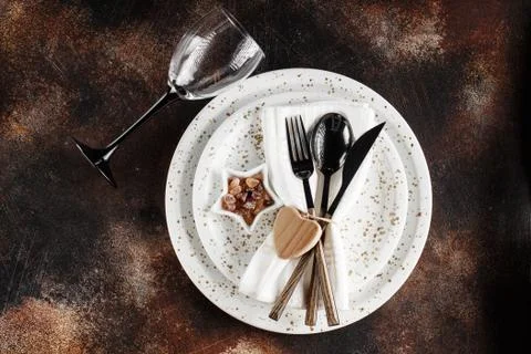 Festive table place setting. Crockery and cutlery on a dark textured backgrou Stock Photos