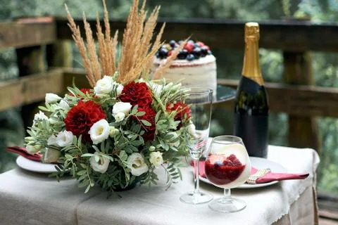 Festive table for a romantic date. Composition of fresh flowers. Summer naked Stock Photos