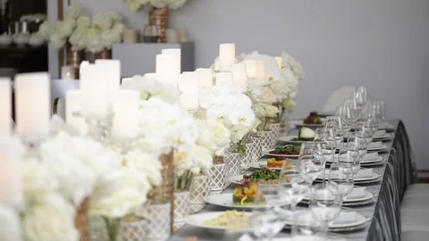 A festive table served by beautiful dishes in white colors surrounded by candles Stock Footage 122525332