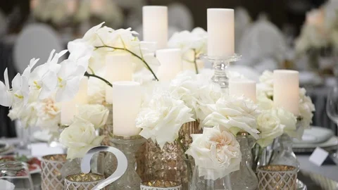 A festive table served by beautiful dishes in white colors surrounded by candles Stock Footage 122525364