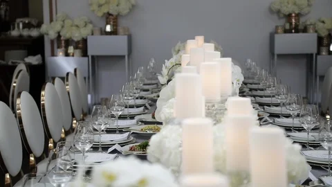 A festive table served by beautiful dishes in white colors surrounded by candles Stock Footage 122525397