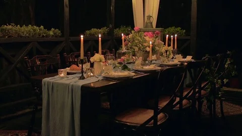Festive table with serving, cloth, croissants, candles, macaroons, flowers. Video stock 76970756