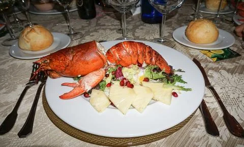 Festive table set with dish of huge grilled lobster and vegetable Stock Photos