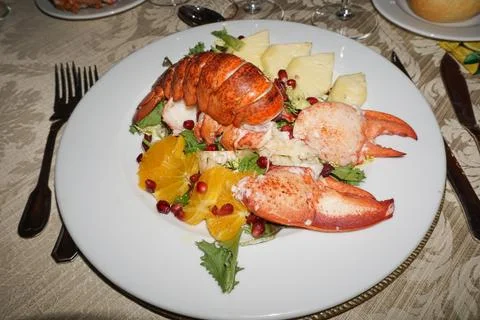 Festive table set with dish of huge grilled lobster and vegetable Stock Photos