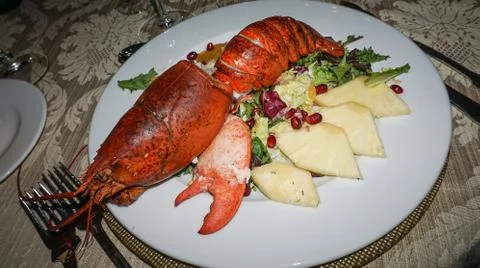 Festive table set with dish of huge grilled lobster and vegetable Stock Photos