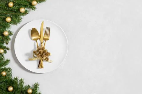 Festive table setting with Christmas decor and utensils, gold accessories Stock Photos