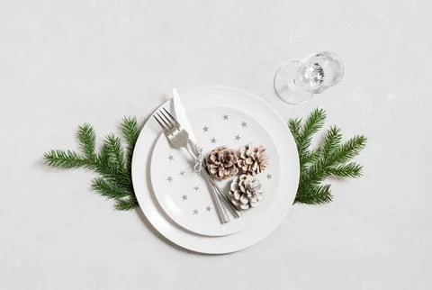 Festive table setting for Christmas dinner with silver cutlery on a white  Stock Photos