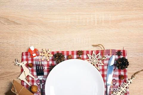 Festive table setting with cutlery, checkered napkin and Christmas decoration Stock Photos